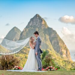 Bruidspaar tijdens een romantische trouwshoot met sluier en uitzicht op de iconische Pitons van St. Lucia. (c) Fotograaf Daniel