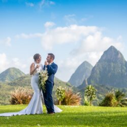 Bruidspaar proost tijdens hun huwelijk met panoramisch uitzicht op de Pitons van St. Lucia. (c) Fotograaf Daniel