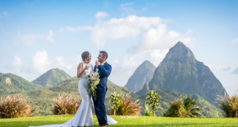 Bruidspaar proost tijdens hun huwelijk met panoramisch uitzicht op de Pitons van St. Lucia. (c) Fotograaf Daniel