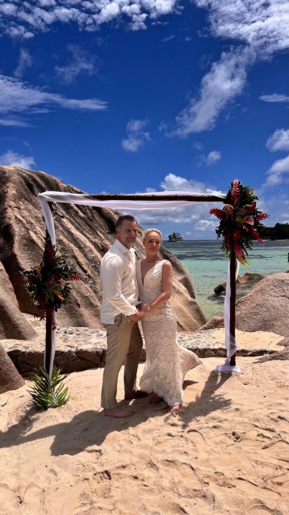 Bruidspaar tijdens een romantische strandbruiloft op de Seychellen tussen granieten rotsen en turquoise zee